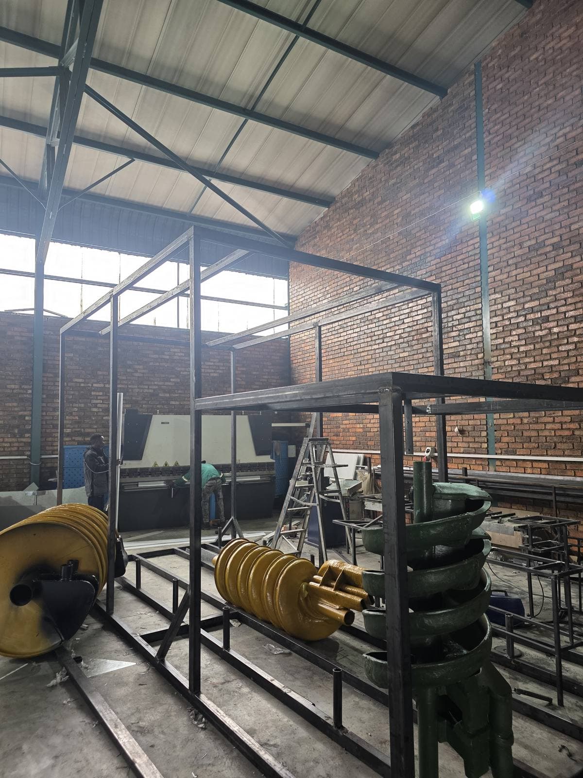 Spiral concentrators and a distributor head being assembled onto the steel frame inside the Trailored workshop