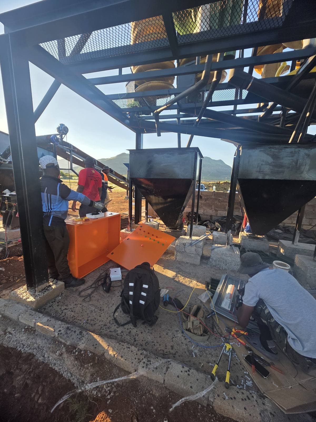 The Trailored team installing and commissioning the washplant on site, wiring the control panel beneath the structure