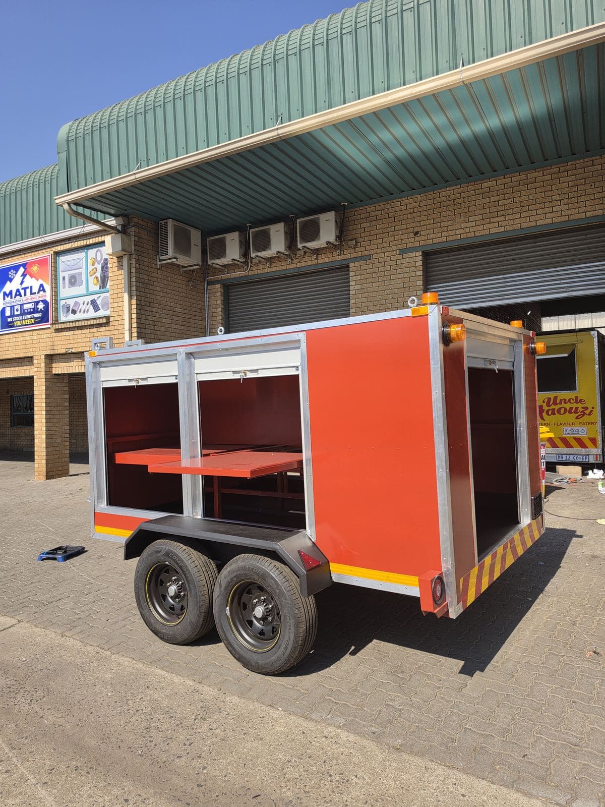 Rear of the hazmat trailer with the shutter open, showing shelves and an open compartment.