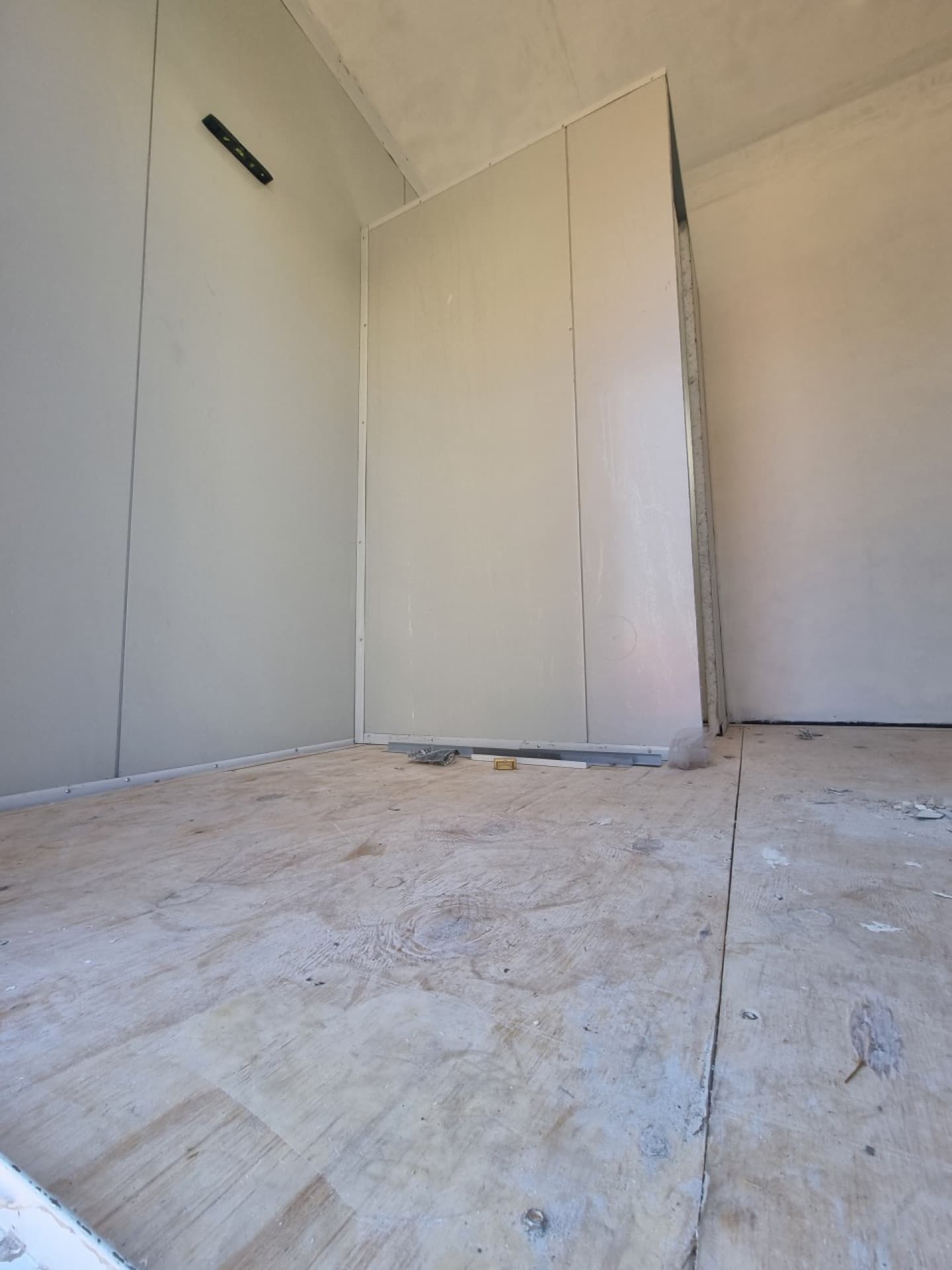 Internal partition walls being built and lined with white melamine board to divide the trailer into rooms
