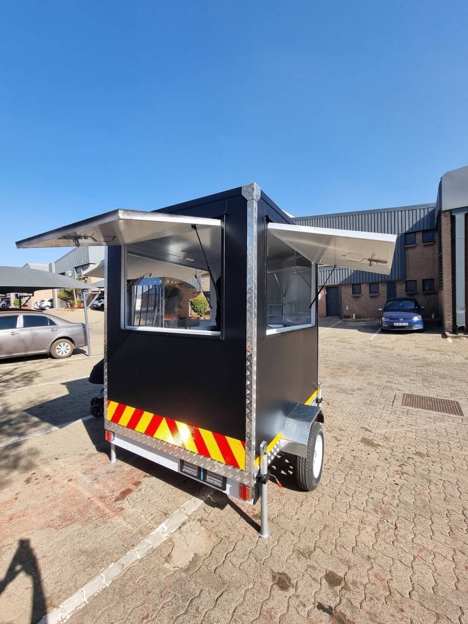 Trailored coffee trailer with serving hatches propped open, exterior view